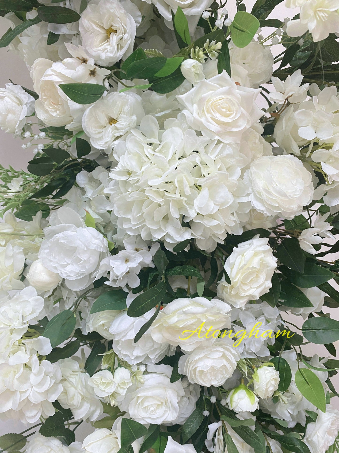 White artificial floral backdrop with greenery